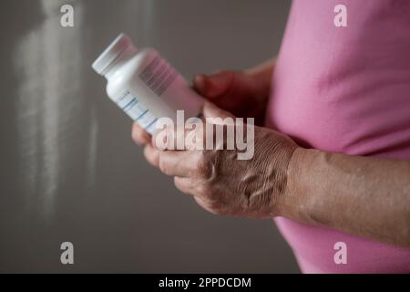 Homme âgé tenant une bouteille de vitamines et de probiotiques Banque D'Images