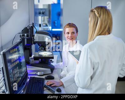 Les scientifiques discutent entre eux travaillant dans E-Laboratory Banque D'Images