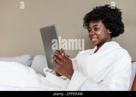 Jeune femme souriante utilisant une tablette PC à la maison Banque D'Images