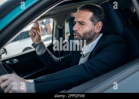 Homme d'affaires joyeux appréciant la musique assis dans la voiture électrique Banque D'Images