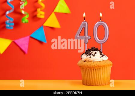 Gâteau d'anniversaire avec bougie numéro 40 - fond orange étincelant avec banderole Banque D'Images