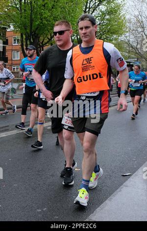 Londres, Royaume-Uni. 23rd avril 2023. Un coureur malvoyants est assisté par un guide qui se poursuit le long de Jamaica Road - le 11th mile de l'itinéraire de 26,2 miles de long. Le marathon de Londres reprend son horaire initial au printemps, après avoir été déplacé à l'automne pendant la pandémie de Covid, avec 47 000 coureurs qui descendent dans la rue. Crédit : onzième heure Photographie/Alamy Live News Banque D'Images