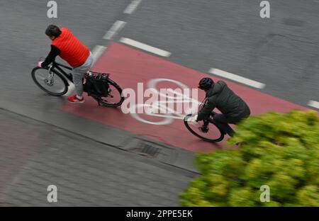 PRODUCTION - 20 avril 2023, Hesse, Francfort-sur-le-main : deux cyclistes sont sur une piste cyclable rouge dans le centre-ville (tourné avec une vitesse d'obturation plus longue). Sur 24 avril 2023, l'ADFC présentera les résultats de l'essai climatique 2022 de la bicyclette pour Hesse. L'enquête de l'automne 2022 vise à fournir des renseignements sur les municipalités de Hesse qui sont particulièrement adaptées aux vélos - et sur les endroits où il est nécessaire de rattraper leur retard. Dans le test de climat à vélo, les citoyens des municipalités allemandes sont interrogés sur leur convivialité à vélo. Photo: Arne Dedert/dpa Banque D'Images