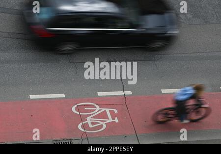 PRODUCTION - 20 avril 2023, Hesse, Francfort-sur-le-main : une cycliste féminine se trouve dans une piste cyclable rouge du centre-ville (prise avec une vitesse d'obturation plus longue). Sur 24 avril 2023, l'ADFC présentera les résultats de l'essai climatique 2022 de la bicyclette pour Hesse. L'enquête de l'automne 2022 vise à fournir des renseignements sur les municipalités de Hesse qui sont particulièrement adaptées aux vélos - et sur les endroits où il est nécessaire de rattraper leur retard. Dans le test de climat à vélo, les citoyens des municipalités allemandes sont interrogés sur leur convivialité à vélo. Photo: Arne Dedert/dpa Banque D'Images
