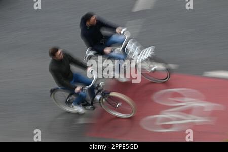 PRODUCTION - 20 avril 2023, Hesse, Francfort-sur-le-main : deux cyclistes sont sur une piste cyclable rouge dans le centre-ville (tourné avec une vitesse d'obturation plus longue). Sur 24 avril 2023, l'ADFC présentera les résultats de l'essai climatique 2022 de la bicyclette pour Hesse. L'enquête de l'automne 2022 vise à fournir des renseignements sur les municipalités de Hesse qui sont particulièrement adaptées aux vélos - et sur les endroits où il est nécessaire de rattraper leur retard. Dans le test de climat à vélo, les citoyens des municipalités allemandes sont interrogés sur leur convivialité à vélo. Photo: Arne Dedert/dpa Banque D'Images