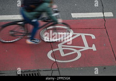 PRODUCTION - 20 avril 2023, Hesse, Francfort-sur-le-main : un cycliste est sur une piste cyclable rouge dans le centre-ville (tourné avec une vitesse d'obturation plus longue). Sur 24 avril 2023, l'ADFC présentera les résultats de l'essai climatique 2022 de la bicyclette pour Hesse. L'enquête de l'automne 2022 vise à fournir des renseignements sur les municipalités de Hesse qui sont particulièrement adaptées aux vélos - et sur les endroits où il est nécessaire de rattraper leur retard. Dans le test de climat à vélo, les citoyens des municipalités allemandes sont interrogés sur leur convivialité à vélo. Photo: Arne Dedert/dpa Banque D'Images