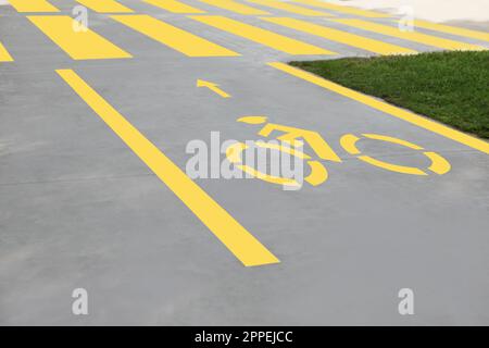 Piste cyclable avec panneau vélo jaune peint et flèche près du passage pour piétons Banque D'Images