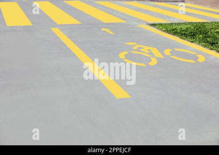 Piste cyclable avec panneau vélo jaune peint et flèche près du passage pour piétons Banque D'Images