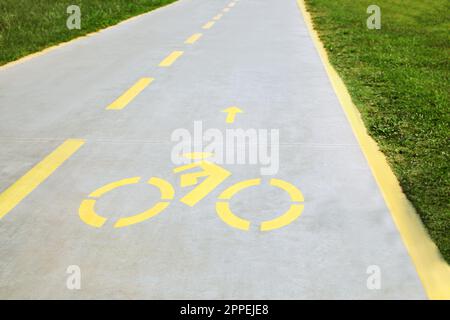 Piste cyclable avec panneau jaune peint et flèche Banque D'Images