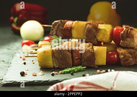 Un plat de viande avec des pommes de terre et des légumes. Délicieux et appétissant, barbecue cuisiné sur brochettes. Hachez le kebab avec les légumes. Placer pour le texte Banque D'Images