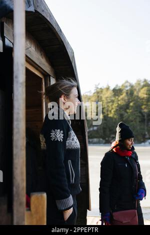 Femme souriante debout devant le sauna Banque D'Images