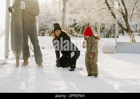 Bonne famille à l'extérieur de la maison en hiver Banque D'Images