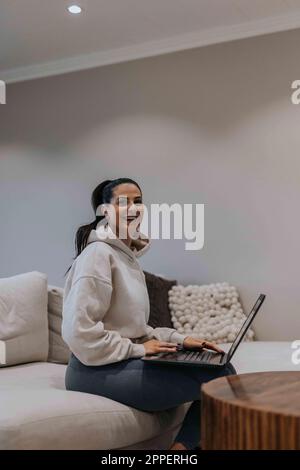 Smiling woman on sofa Banque D'Images