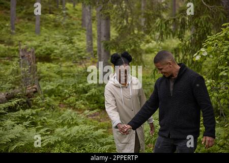 Smiling couple walking through forest Banque D'Images