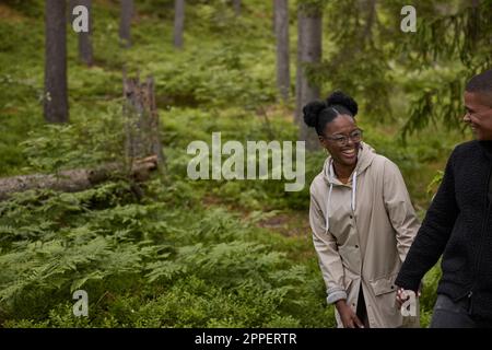 Smiling couple walking through forest Banque D'Images