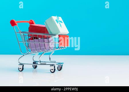 Panier rempli de cadeaux isolés sur fond bleu. Concept de Noël, d'anniversaire et de vente Banque D'Images