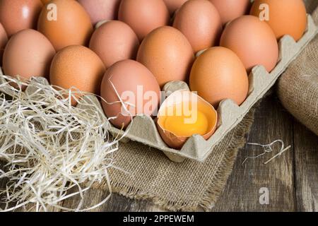 Œufs de poulet fraîchement cueillis sur un fond rustique. Oeufs de poulet dans le foin, scène rurale Banque D'Images