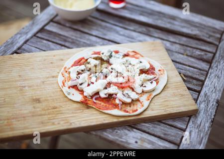 Pizza maison sur planche à découper en bois Banque D'Images