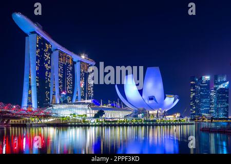 Vue nocturne sur Marina Bay à Singapour, y compris le Marina Bay Sands Hotel et le musée ArtScience en forme de lotus. Banque D'Images