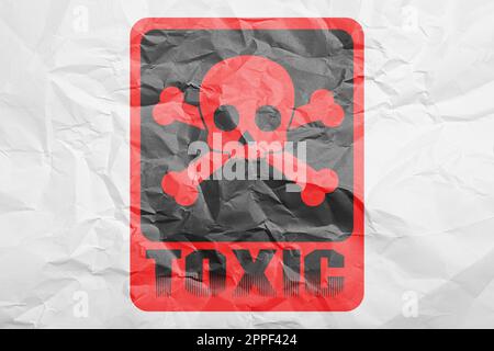 Panneau d'avertissement de danger (symbole crâne et crossos et mot TOXIQUE) sur papier blanc froissé, vue du dessus Banque D'Images