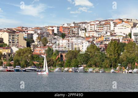 Bateaux amarrés sur la côte de la Corne d'Or, avec fond de parc vert avec de gros arbres denses, et maisons résidentielles, dans un jour ensoleillé d'été, Istanbul, Turquie Banque D'Images