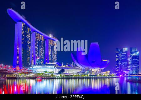 Vue nocturne sur Marina Bay à Singapour, y compris le Marina Bay Sands Hotel et le musée ArtScience en forme de lotus. Banque D'Images