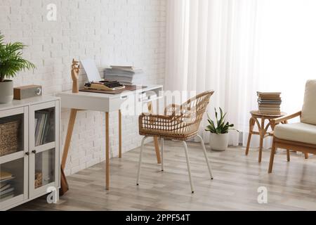 Intérieur confortable du lieu de travail de l'écrivain avec machine à écrire sur le bureau près du mur de briques blanches Banque D'Images