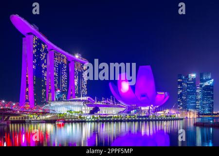 Vue nocturne sur Marina Bay à Singapour, y compris le Marina Bay Sands Hotel et le musée ArtScience en forme de lotus. Banque D'Images