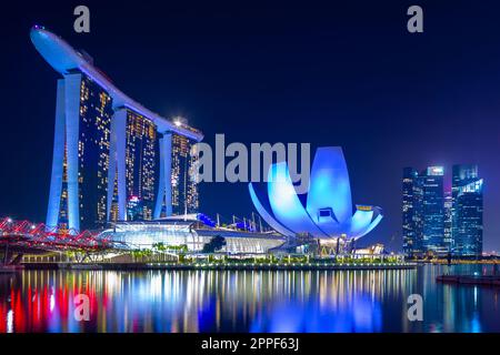 Vue nocturne sur Marina Bay à Singapour, y compris le Marina Bay Sands Hotel et le musée ArtScience en forme de lotus. Banque D'Images