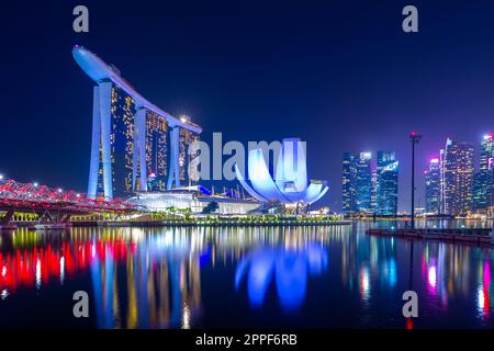 Vue nocturne sur Marina Bay à Singapour, y compris le Marina Bay Sands Hotel et le musée ArtScience en forme de lotus. Banque D'Images