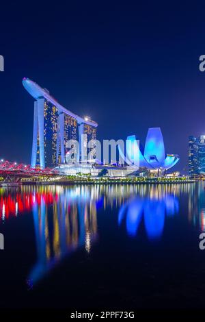 Vue nocturne sur Marina Bay à Singapour, y compris le Marina Bay Sands Hotel et le musée ArtScience en forme de lotus. Banque D'Images