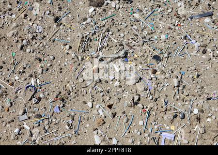 Plage sale pleine de plastique, de microplastique, de bouteilles, de pailles et de divers déchets. Banque D'Images