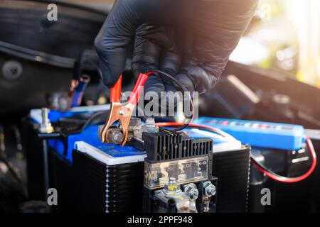 Vérification du niveau de batterie d'une voiture avec le vérificateur de batterie de voiture, concept de réparation de voiture Banque D'Images