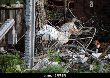 DOLYNA, UKRAINE - 23 AVRIL 2023 - On voit Un cheval à bascule sur les ruines d'une maison ruinée dans le bombardement des troupes russes, Dolyna, région de Donetsk, e Banque D'Images