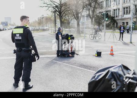 Berlin, Allemagne. 24th avril 2023. Un militant du mouvement de protestation 'dernière génération' est coupé par la police après une action de blocage de la rue Ernst-Reuter-Platz à Berlin, 24 avril 2023. Le mouvement a annoncé d'autres manifestations et blocages. Credit: dpa/Alay Live News Banque D'Images