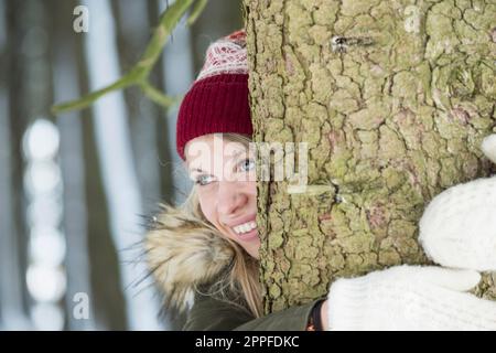 Adolescente embrassant un arbre dans une forêt, Bavière, Allemagne Banque D'Images