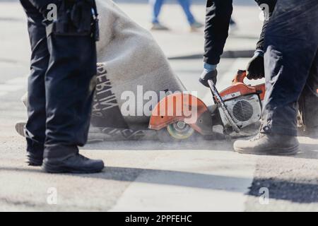 Berlin, Allemagne. 24th avril 2023. Un militant du mouvement de protestation 'dernière génération' est coupé par la police après une action de blocage de la rue Ernst-Reuter-Platz à Berlin, 24 avril 2023. Le mouvement a annoncé d'autres manifestations et blocages. Credit: dpa/Alay Live News Banque D'Images