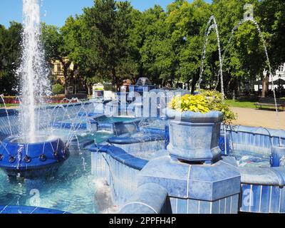 Subotica, Serbie 12 septembre 2021. Fontaine bleue sur la place à côté de la mairie. Pièces en céramique bleue avec monogrammes. Une fontaine de travail avec des éclaboussures d'eau. Journée ensoleillée d'été au bord de l'eau bleue Banque D'Images