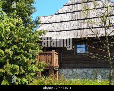 Ferme de village en rondins. Habitation traditionnelle de montagne bosniaque du 19e siècle. Bâtiment ethno restauré, instruments du travail agricole. Banque D'Images