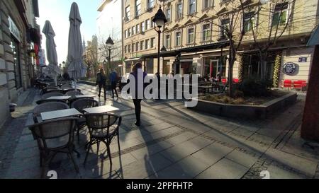 Belgrade, Serbie - 24 janvier 2020 : rue du matin dans le centre-ville. Les gens se précipitent à propos de leurs affaires. Les cafés de rue sont toujours fermés. Tables, chaises et parasols. Les filles marchent énergiquement Banque D'Images