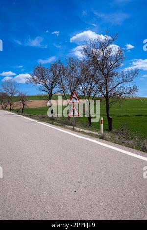 Panneaux de signalisation routière sur fond de montagnes vertes luxuriantes Banque D'Images