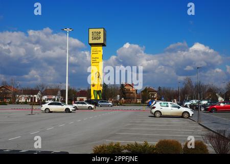 Épicerie Stop and Shop, poteau Stop Shop avec des noms de marque, peint en jaune. Parking devant un grand centre commercial. Sremska Mitrovica, Serbie, 16 mars 2023 Manie du shopping et consumérisme. Banque D'Images