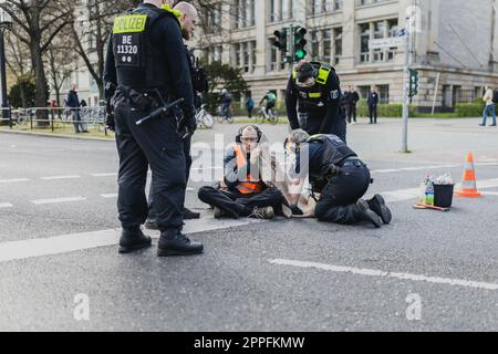 Berlin, Allemagne. 24th avril 2023. Un militant du mouvement de protestation 'dernière génération' est coupé par la police après une action de blocage de la rue Ernst-Reuter-Platz à Berlin, 24 avril 2023. Le mouvement a annoncé d'autres manifestations et blocages. Credit: dpa/Alay Live News Banque D'Images