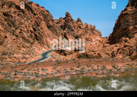Route sinueuse dans le désert avec des montagnes rougeâtres dans le bkgrnd Banque D'Images