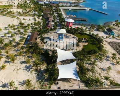 Plage sur Ocean Cay Bahamas Island avec des maisons colorées et de l'eau turquoise Banque D'Images