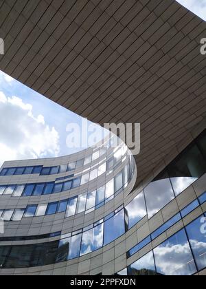 Dusseldorf, Allemagne - 16 juillet 2022 : l'architecture moderne du DÃ¼sseldorfer KÃ¶bogen en été montre une façade en verre attrayante et extravagante d'un centre commercial organique et sinueux avec des nuages de ciel bleu Banque D'Images