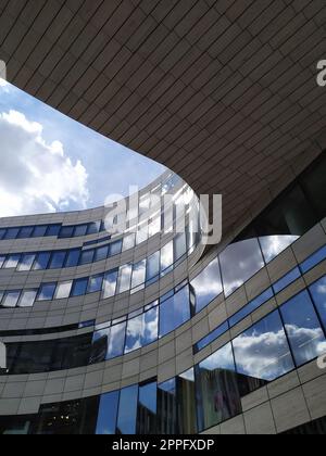 Dusseldorf, Allemagne - 16 juillet 2022 : l'architecture moderne du DÃ¼sseldorfer KÃ¶bogen en été montre une façade en verre attrayante et extravagante d'un centre commercial organique et sinueux avec des nuages de ciel bleu Banque D'Images