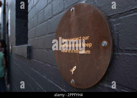 Signez avec le logo « Veuillez respecter nos voisins et réduire le bruit au minimum » sur le mur de la célèbre Lune Croissanterie à Fitzroy à Melbourne Banque D'Images