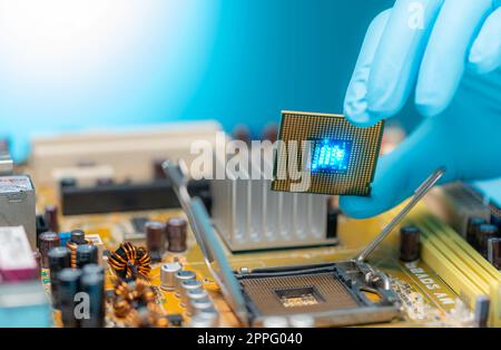 Ingénieur en électronique mettant la puce d'ordinateur sur la prise. Chipset sur la carte électronique de la carte mère du PC. Puce UC. Composants électroniques. Matériel informatique. Mise à niveau de la puce du processeur. Banque D'Images