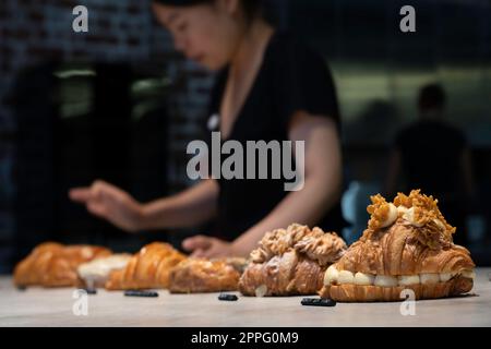 Au comptoir de la Lune Croissanterie de Fitzroy, à Melbourne, vous trouverez quelques croissants de luxe. Le personnel aide les clients. Concentrez-vous sur le croissant sur la droite Banque D'Images